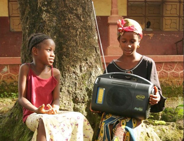 girl students under a tree with a large radio