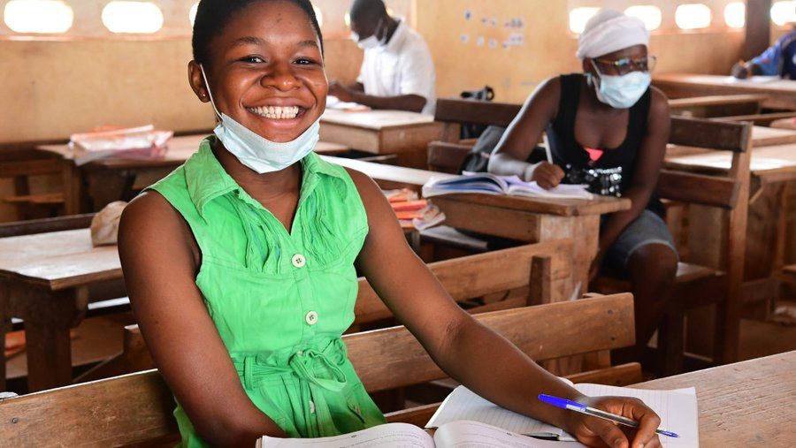 school girl in a green dress in a classroom