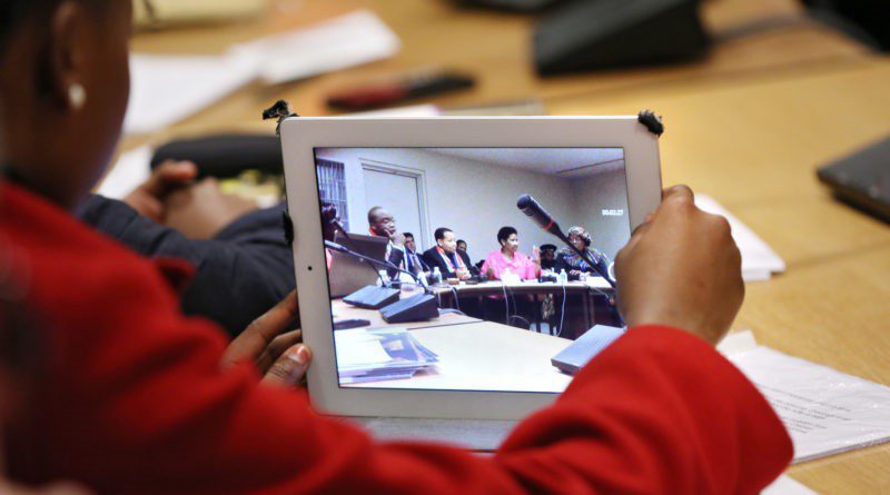 person watching a meeting via a tablet