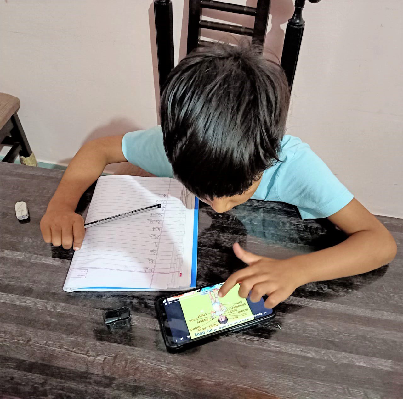 Primary age boy home learning with a mobile phone