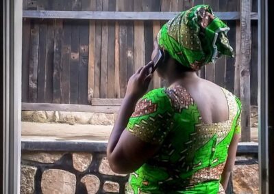 African woman in green dress using a mobile phone