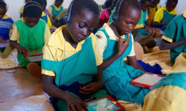 Children in class with headphones working on tablets