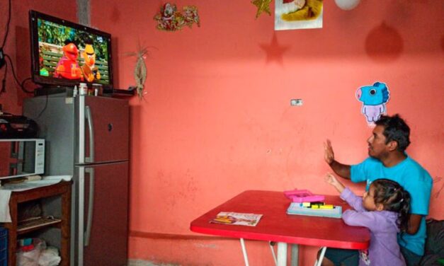 Father and daughter home learning and interacting with tv lesson with Sesame Street characters