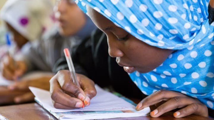 A school girl at a primary school in Mauritania, writing at a desk