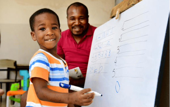 father and son home learning at a whiteboard