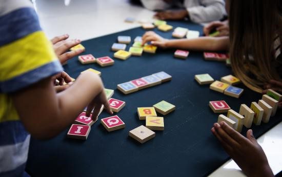 Children's hands working with letter tiles