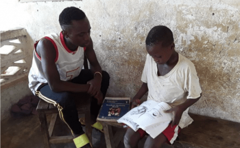 Boys sitting looking at a book