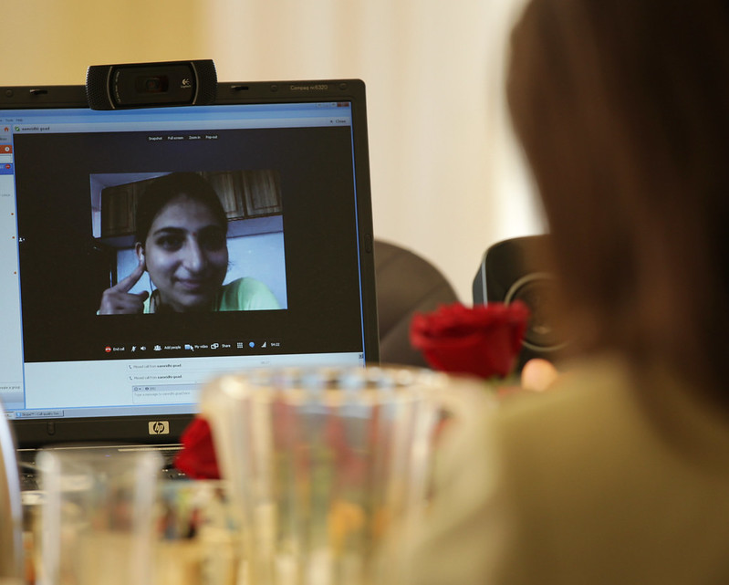 someone looking at a laptop with a video call displayed