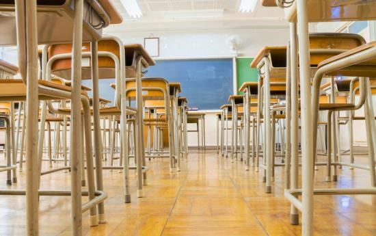 An empty classroom taken through table and chair legs at floor level