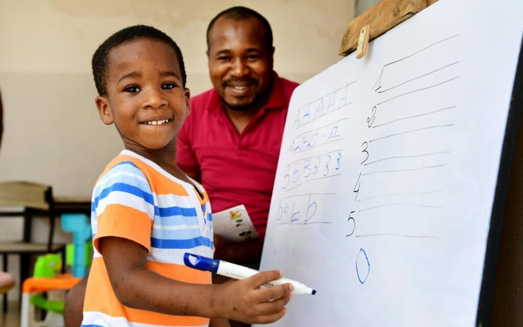 Nigerian father and son at an easel - home learning