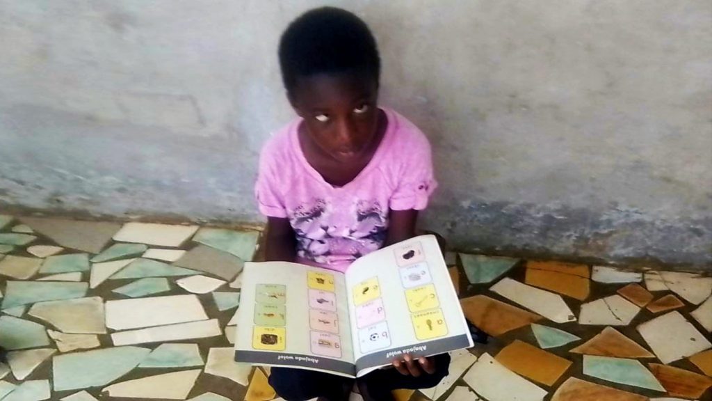 Blind girl in Senegal with books