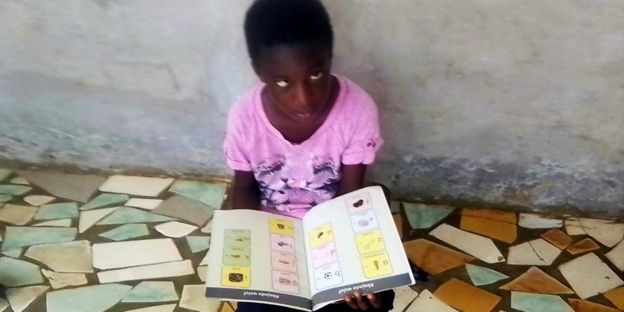 Blind girl in Senegal with books