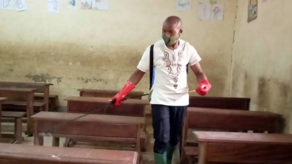 man disinfecting a classroom in Cameroon