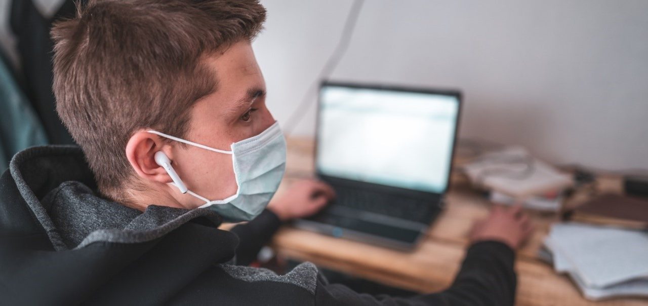 Student wearing a mask with laptop