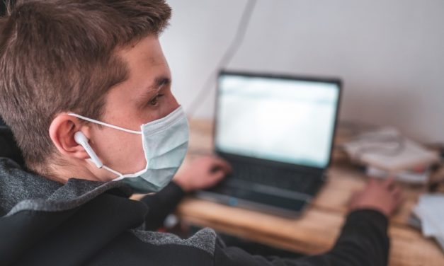 Student wearing a mask with laptop