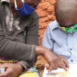 Teacher working with a child - wearing masks