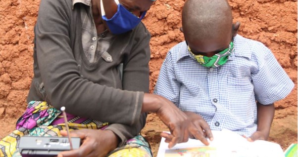 Teacher working with a child - wearing masks