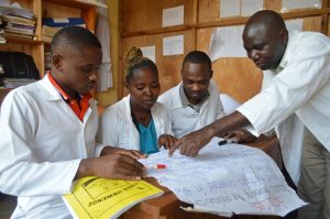 Rwandan mentor and teachers looking at learning materials