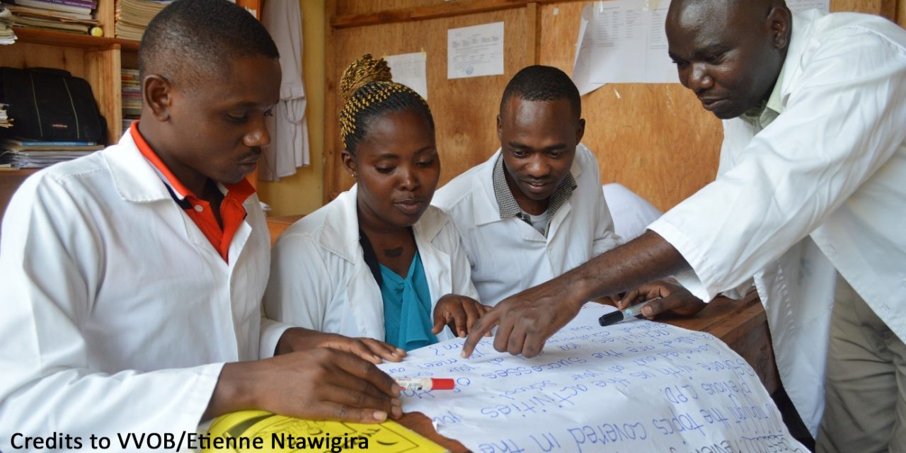 Rwandan mentor and teachers looking at learning materials