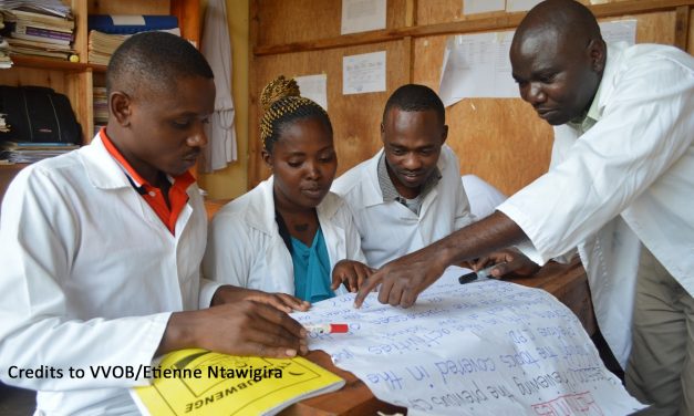 Rwandan mentor and teachers looking at learning materials
