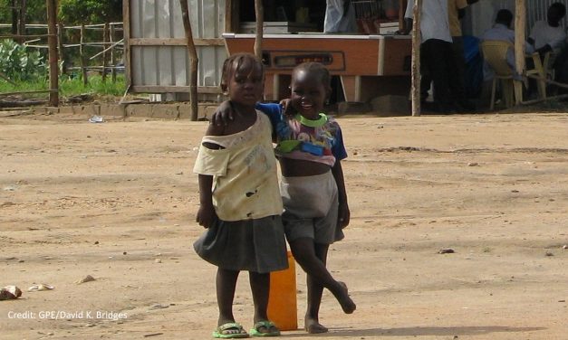 Two young girls in front of a building in South Sudan