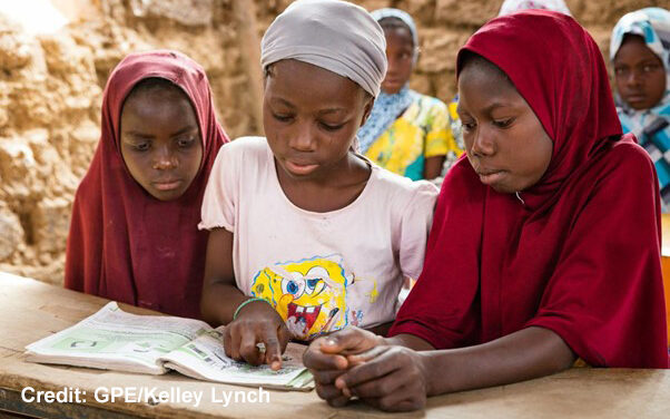 Three Girls looking at a book in a classroom in Niger