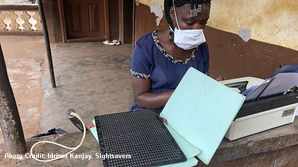 Girl typing braille notes during a radio lesson