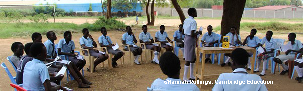 Outside classroom with students sitting on chars in circle around the teacher