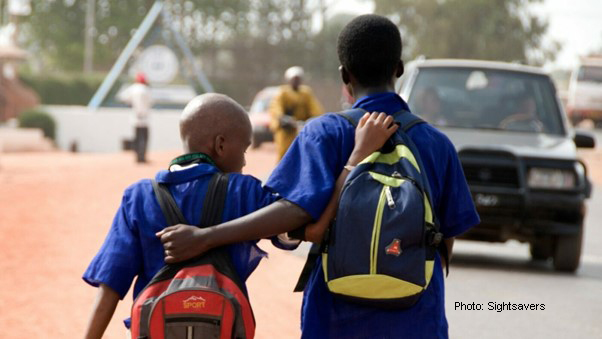 African origin boys with backpacks, arms around each other