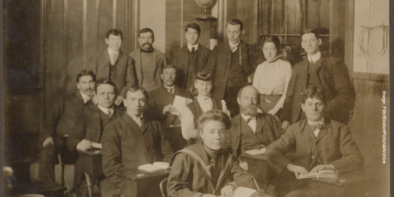 a sepia tinted photograph of students in period dress with women students among them