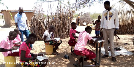 Outside classroom with teachers and students working at desks