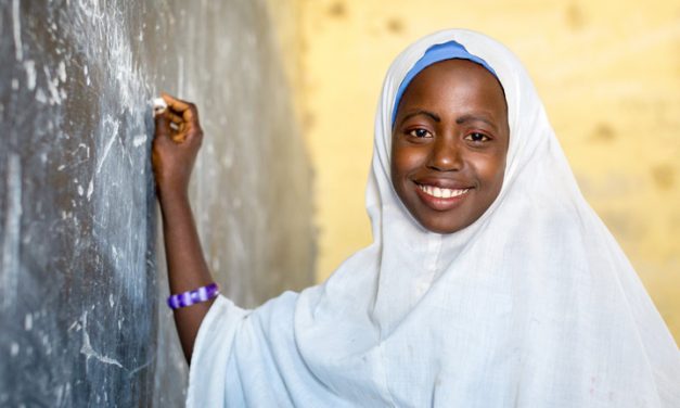 Nigierian school girl in headscarf at blackboard