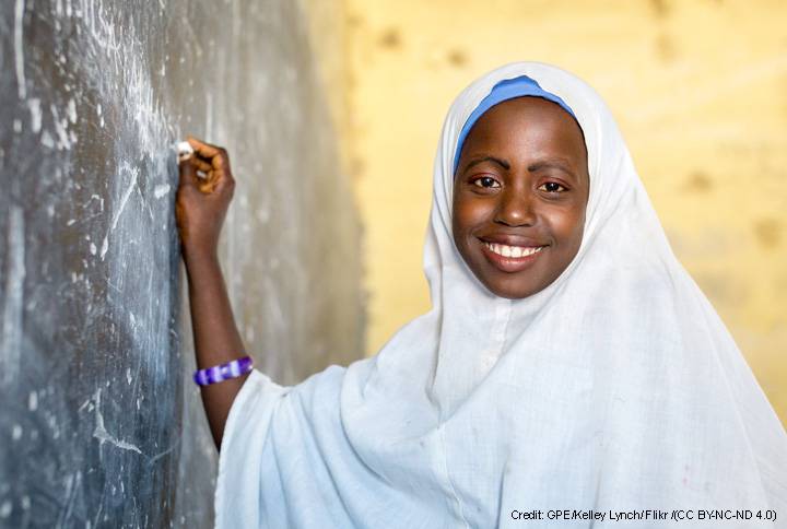 Nigierian school girl in headscarf at blackboard