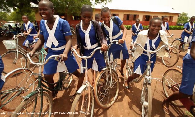 African School girls in uniform on bicyles