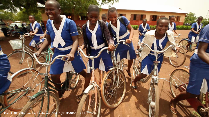 African School girls in uniform on bicyles