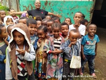 Ehtiopia pre-primary children outside their classroom with a teacher