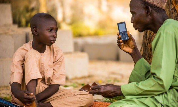 Boy and man with mobile phone listening to a lesson