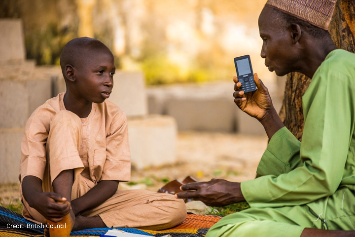 Boy and man with mobile phone listening to a lesson