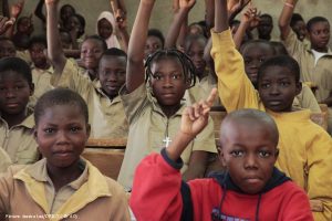 African Children with hands up in class