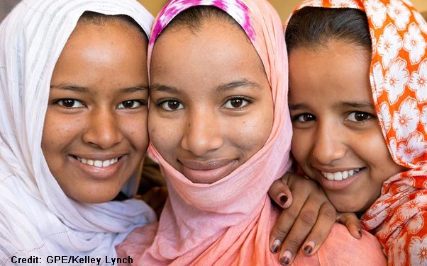 three smiling girls wearing headscarves