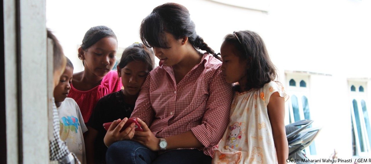 Group of children looking at a mobile phone