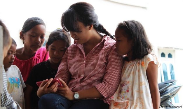 Group of children looking at a mobile phone