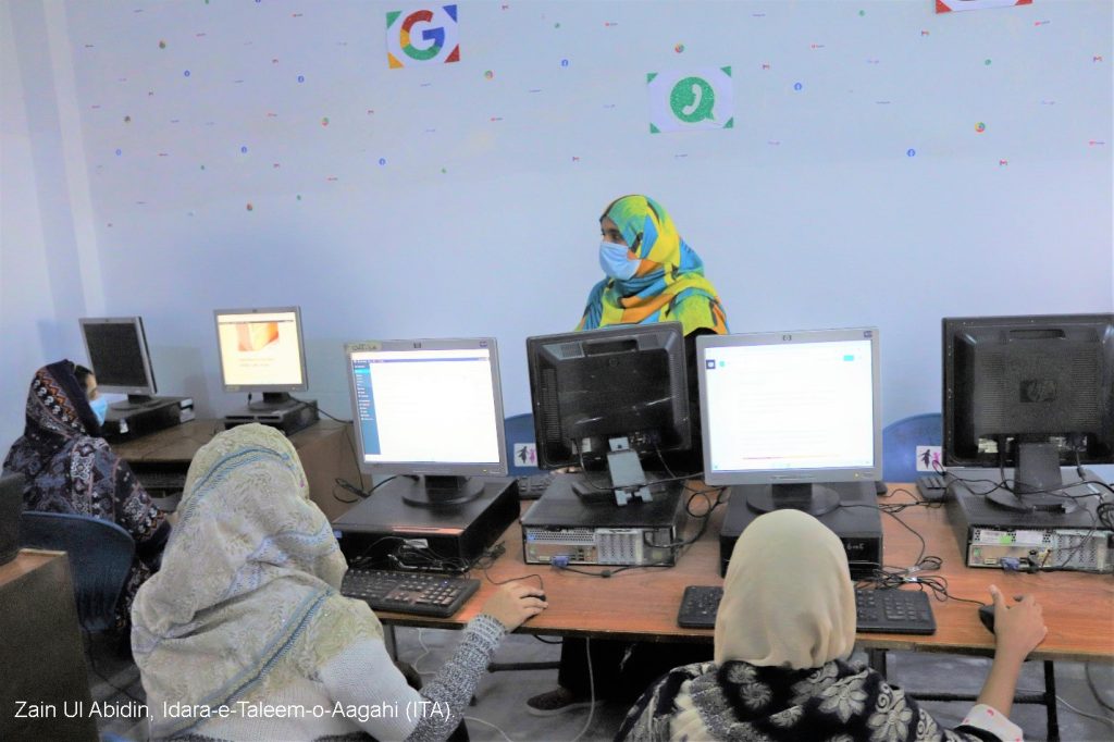 A group of adolescent girls being trained in coding on computers