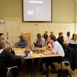 workshop at UKFIET Conference 2019 with groups sitting around tables in discussion.