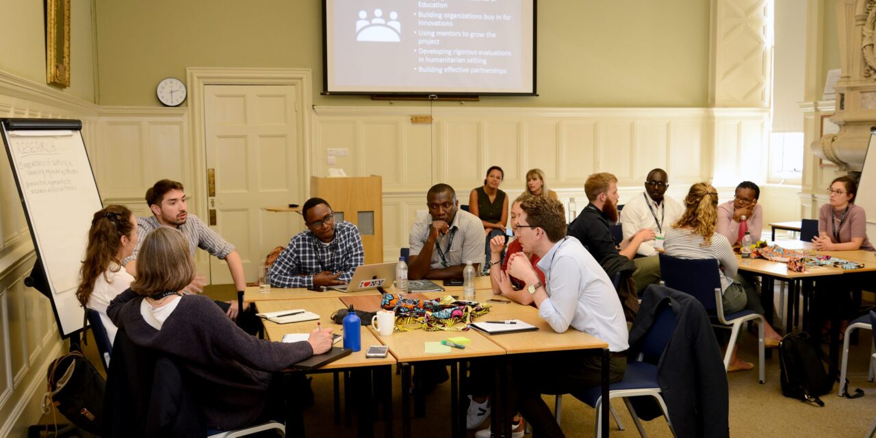 workshop at UKFIET Conference 2019 with groups sitting around tables in discussion.