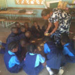 A teacher engages students through play in the classroom in Zambia