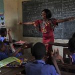 female teacher laughing with children in the classroom, Sierra Leone