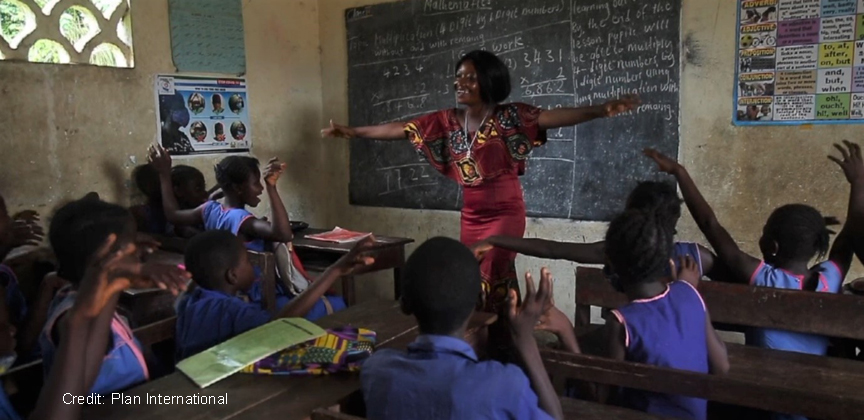 female teacher laughing with children in the classroom, Sierra Leone