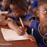Girl writing in her notebook in class, Sierra Leone