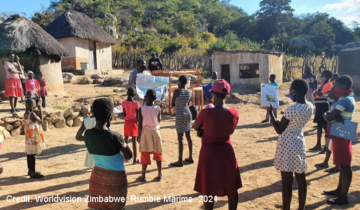 Teaching volunteer holds an informal community learning circle class outside in a rural village with social distancing and masks, Zimbabwe.